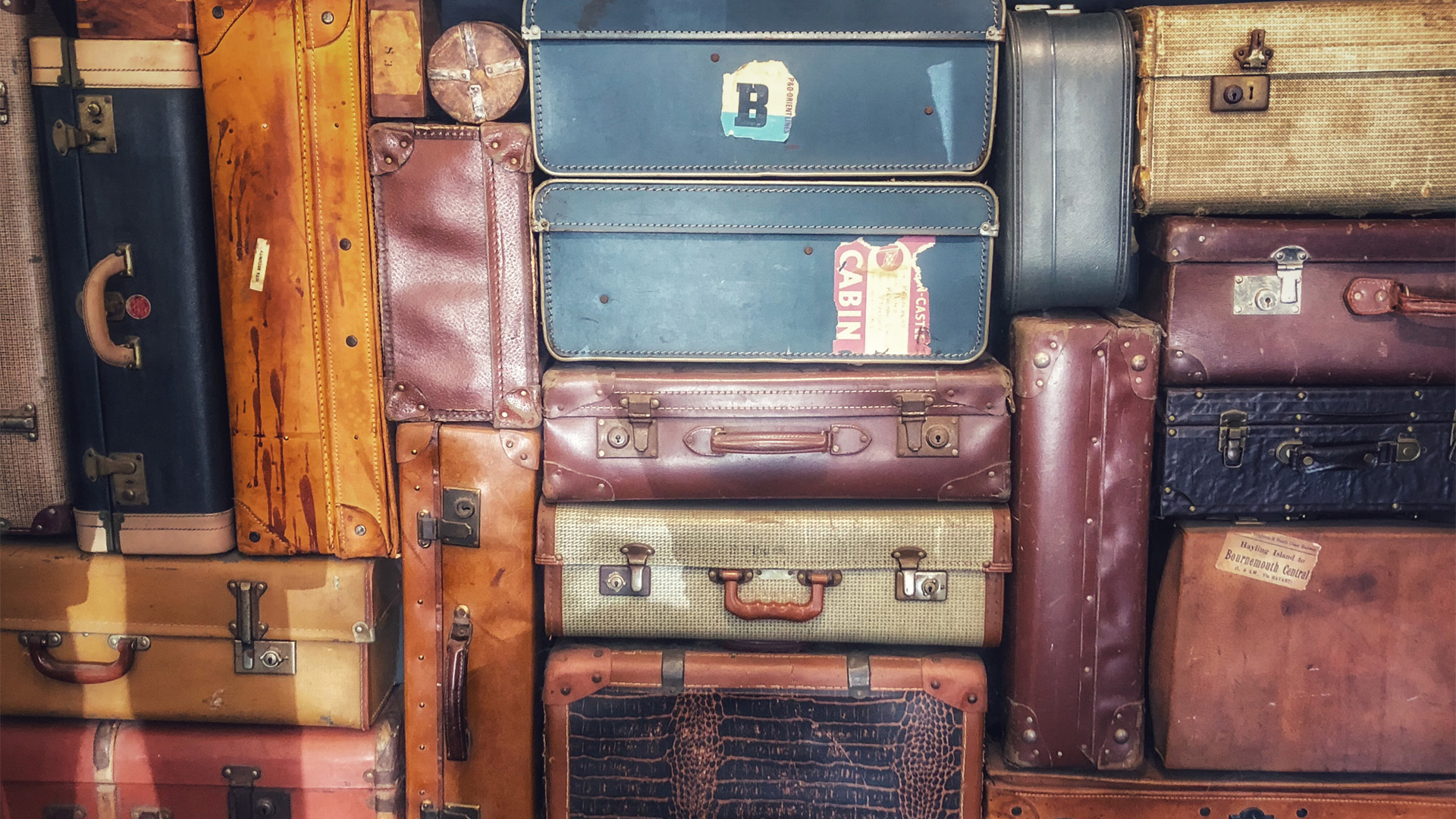 decorative: image of a large stack of suitcases of varying sizes