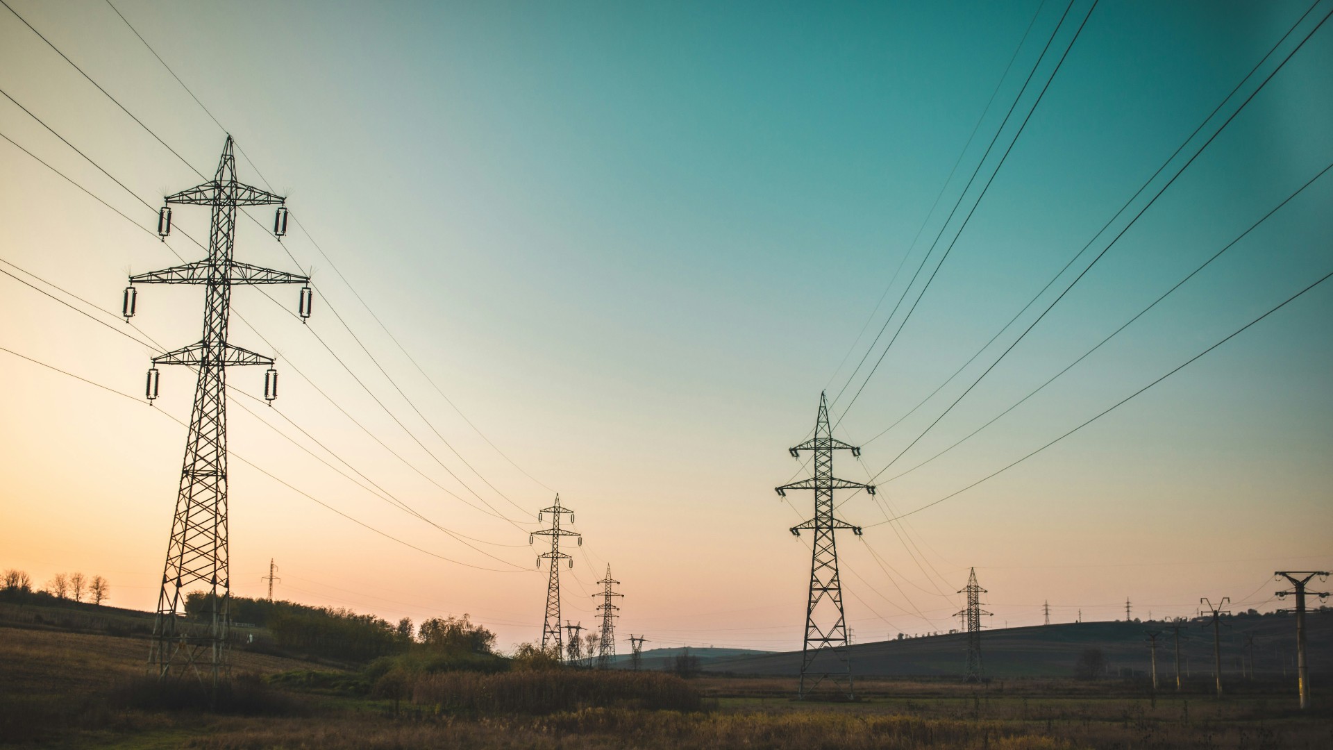Landscape photography of electric towers under a calm blue sky